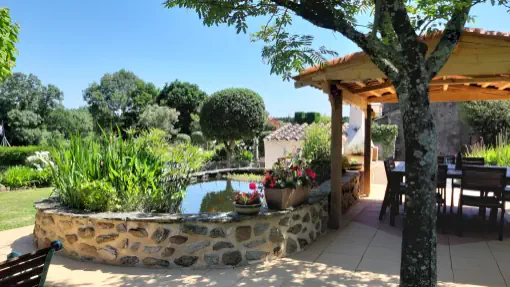 Coin repas extérieur au bord de l'étang. grand gîte de style ferme